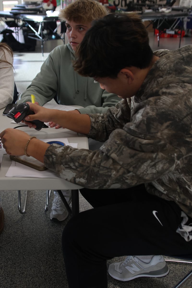 Focused, sophomore Josh Garcia holds the scanner as he scans a donor’s ID.
