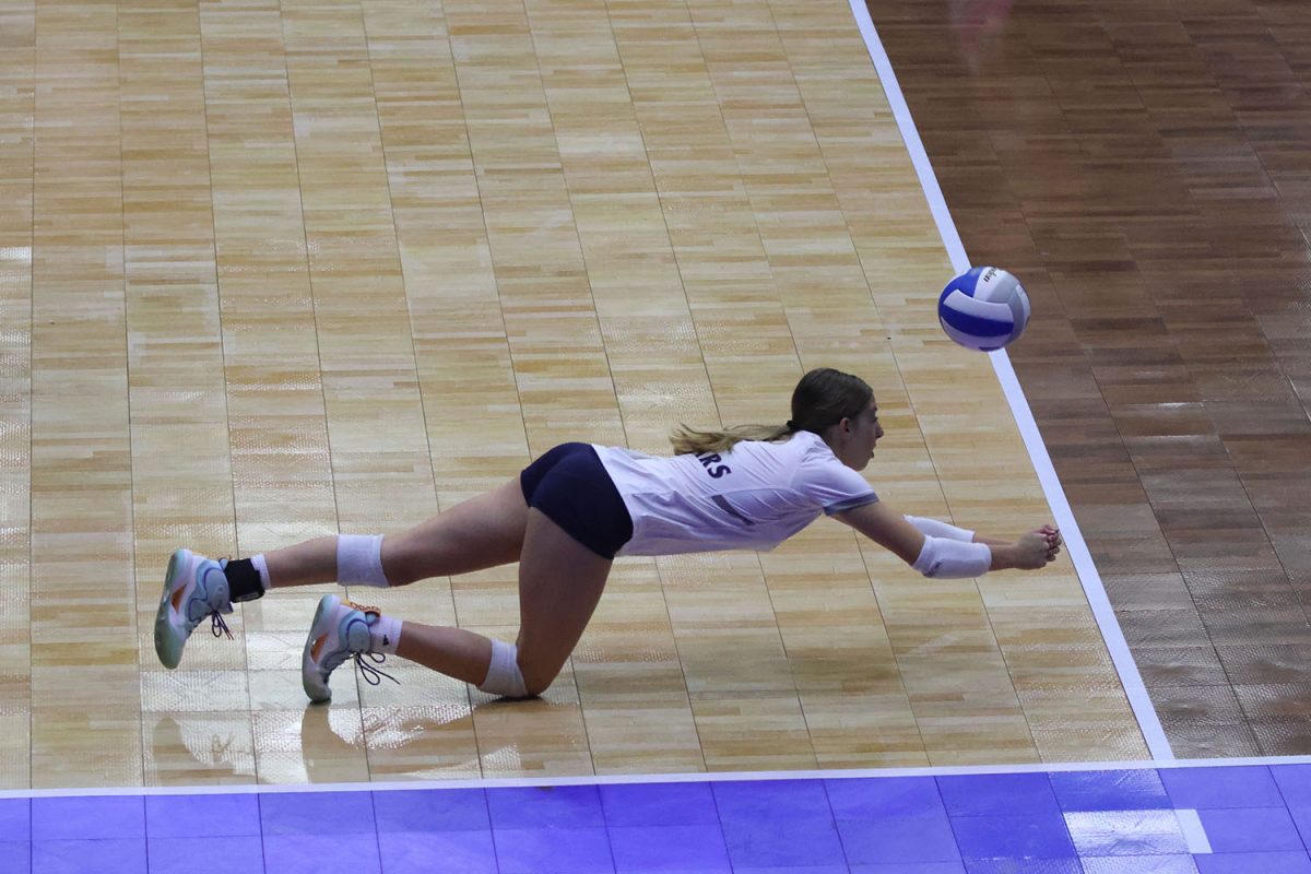 As she dives forward, freshman Ellie Bain saves the ball from hitting the ground.