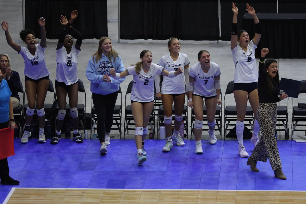 After a big play versus Olathe West, the players on the sideline cheer for their teammates after they won a point.