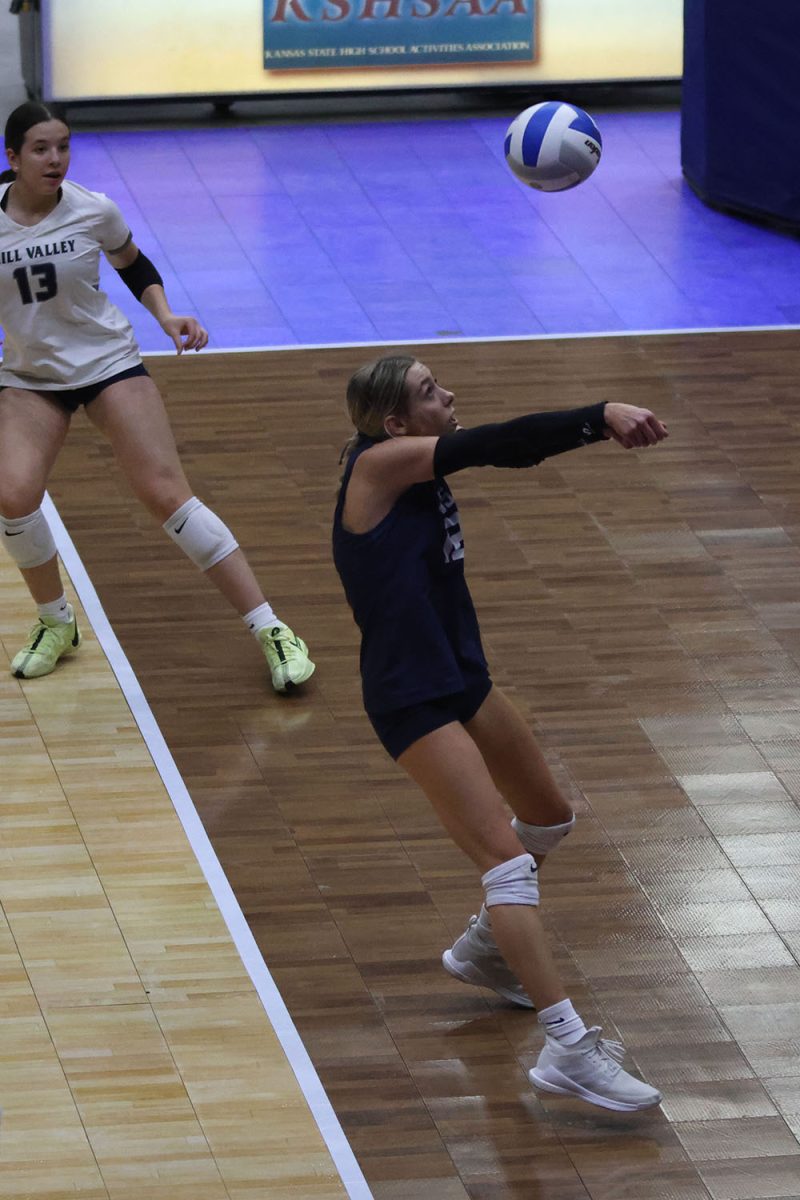 Arms extended, junior Corinne Schwindt passes the ball to her teammate.