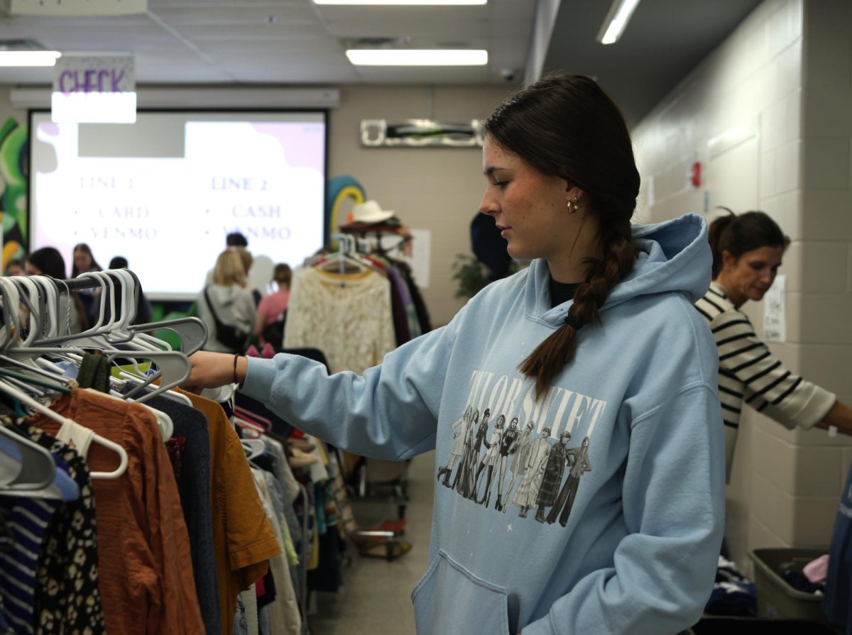 Looking at a row of shirts, junior Paige Roth decides what she wants to buy. 