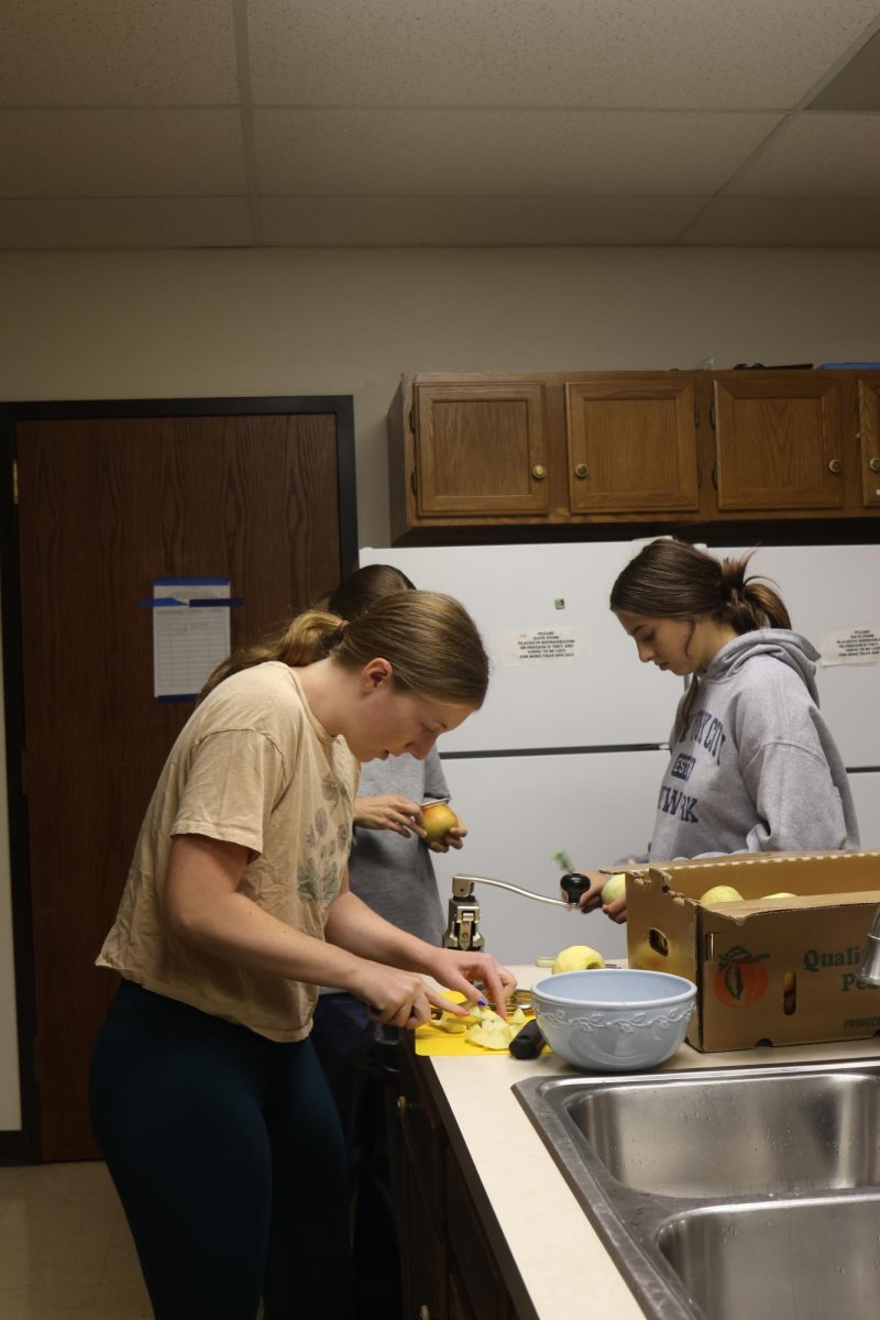 Senior Elly Hayes peels and chops up apples to add to the apple pies. These pies will later be sent fresh to the Desoto Food Pantry for people to cook at home.  