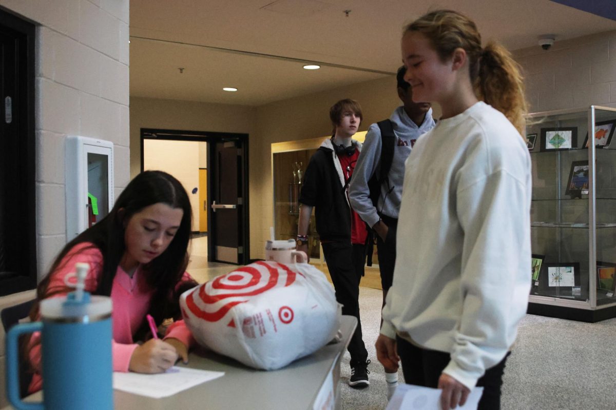 Junior Abby Allen writes down information on Junior Kylie Stegner’s pet donations for the Great Plains SPCA supplies drive. 