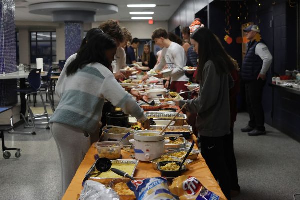 Students load their plates at clubsgiving. 
