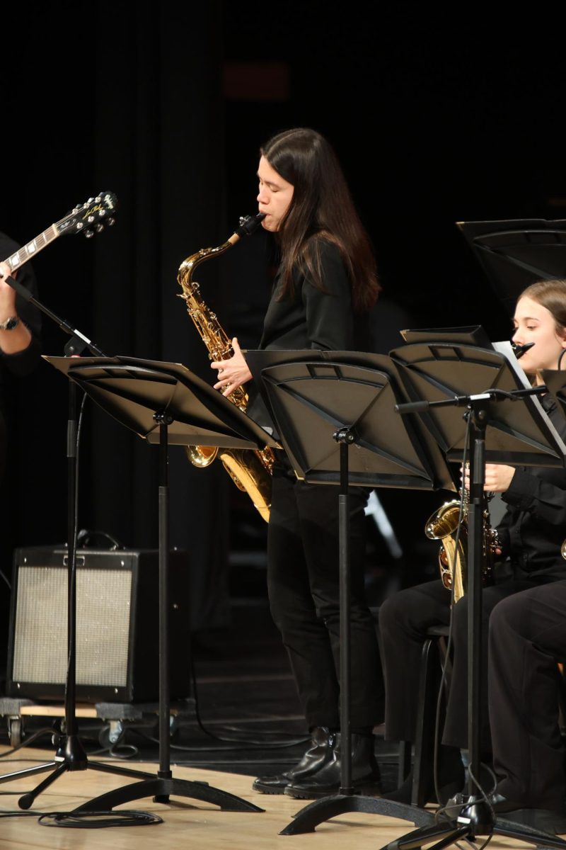 Standing, senior Sophie Hsu plays a solo on the saxophone.