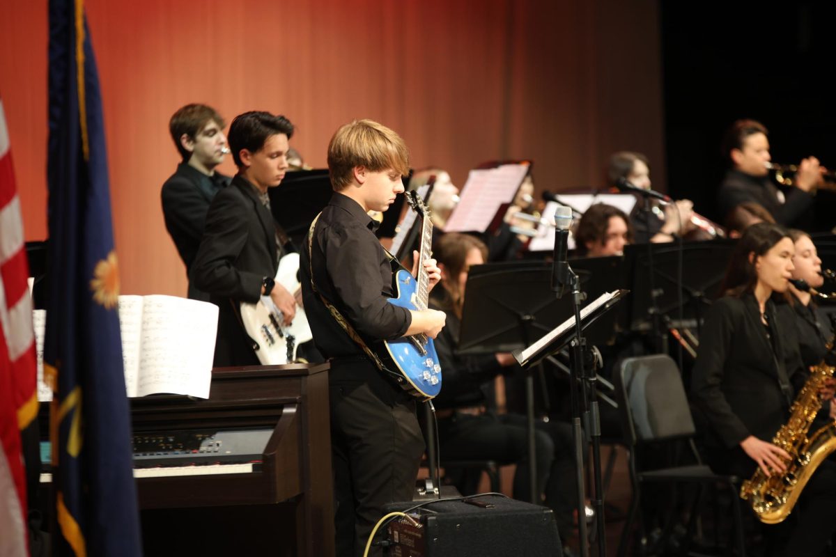 Strumming, senior Zach Chesser plays the bass guitar.