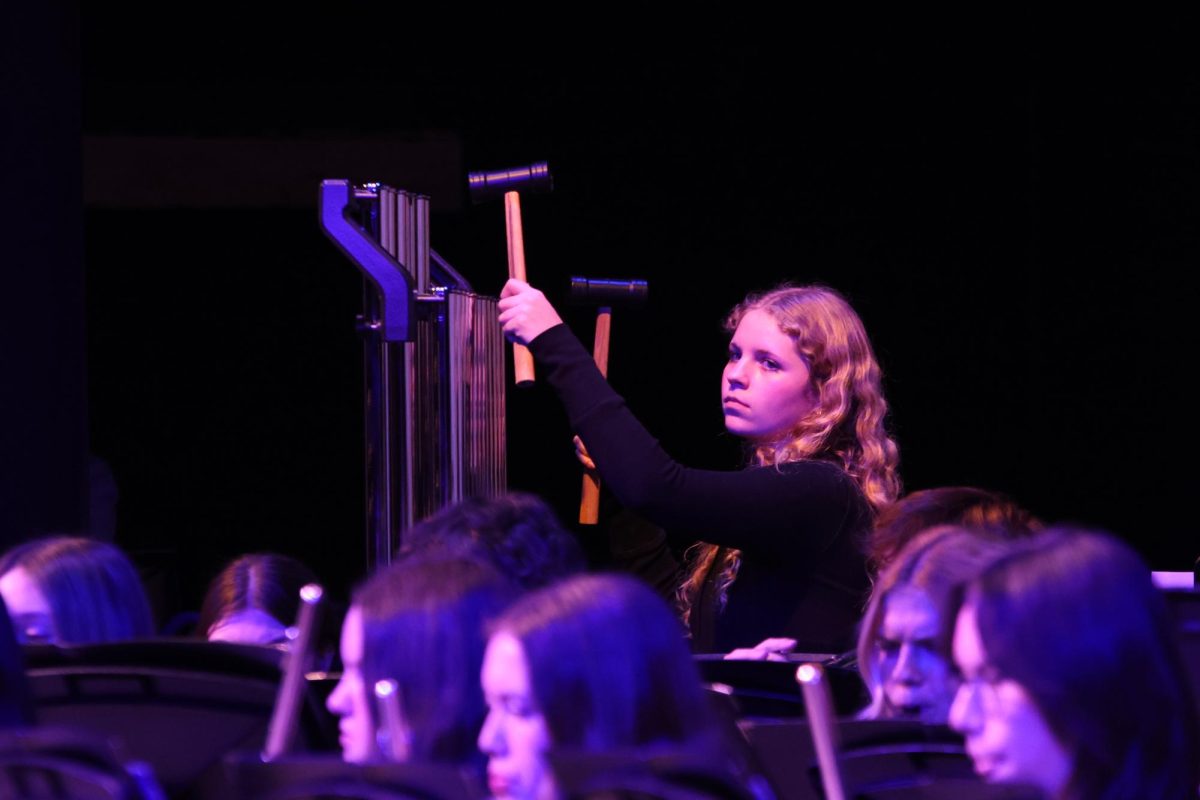 With her eyes on the conductor, junior Abby Haney waits for her cue to play the chimes.