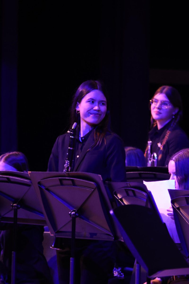 With a smile on her face, senior Sophie Hsu stands as band teacher Deb Steiner recognizes students qualifying for honor groups.