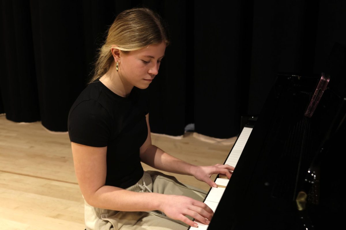 Looking down at the keys, sophomore Peyton Heinrich practices her song. 
