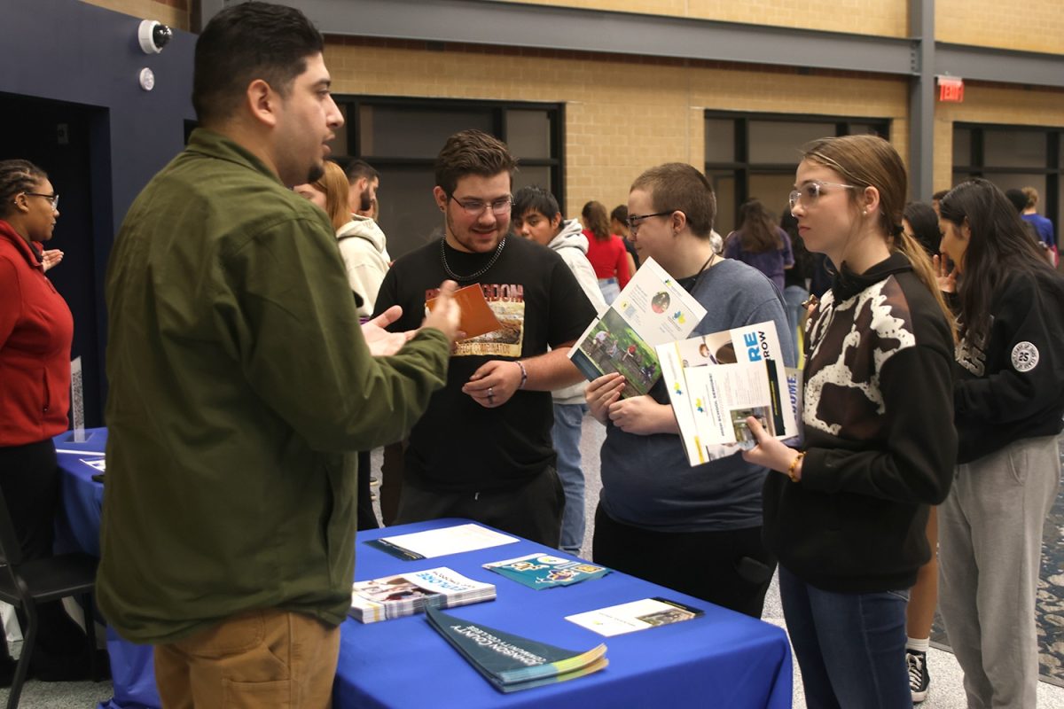 Planning for the future, seniors Bella Supica, Wyatt Wardle and Axel Brooks talk to the sponsor for Johnson County Community College on the last day of next steps, Thursday Oct. 31.