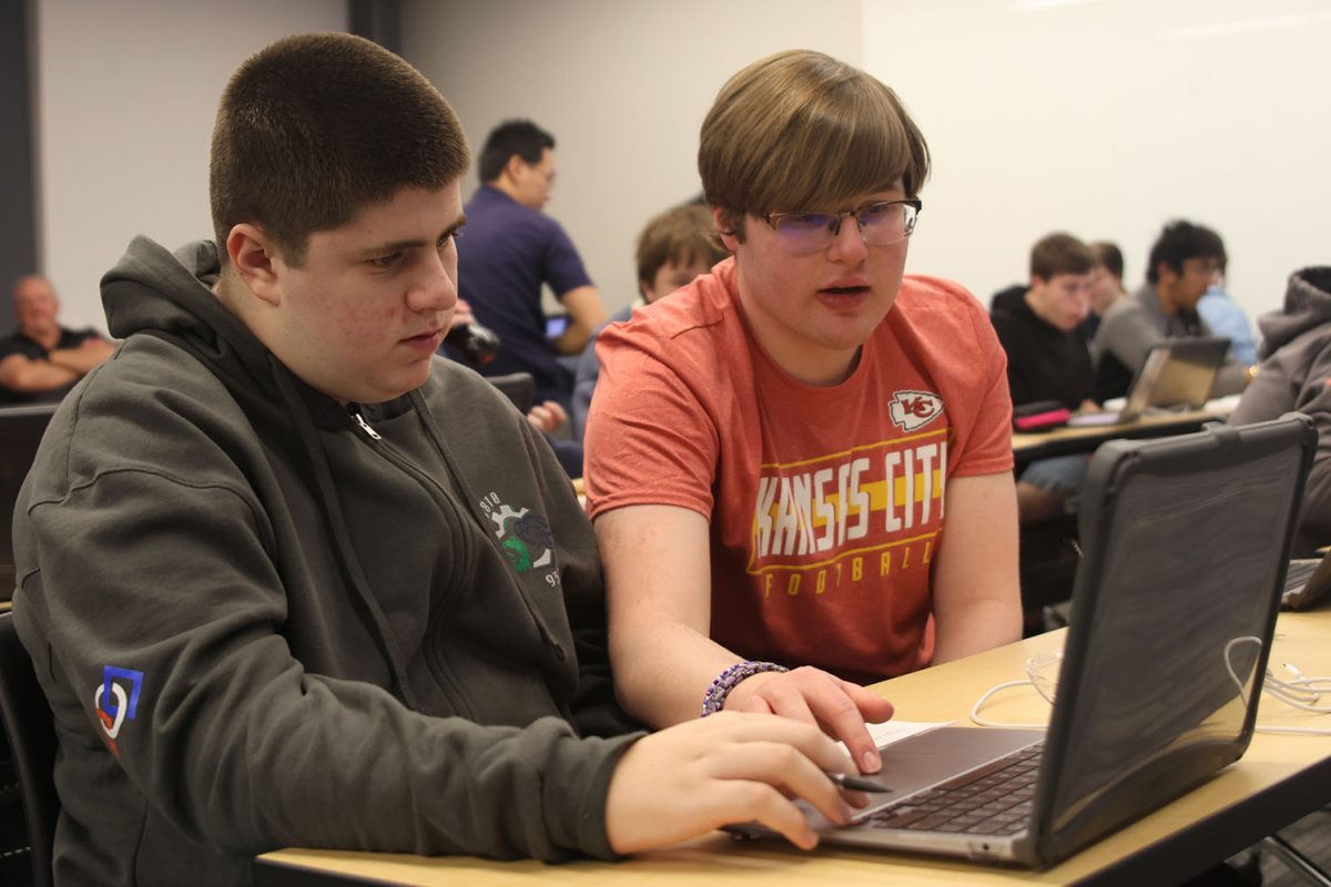 Helping out on the computer, junior Ian Weatherman guides his partner.