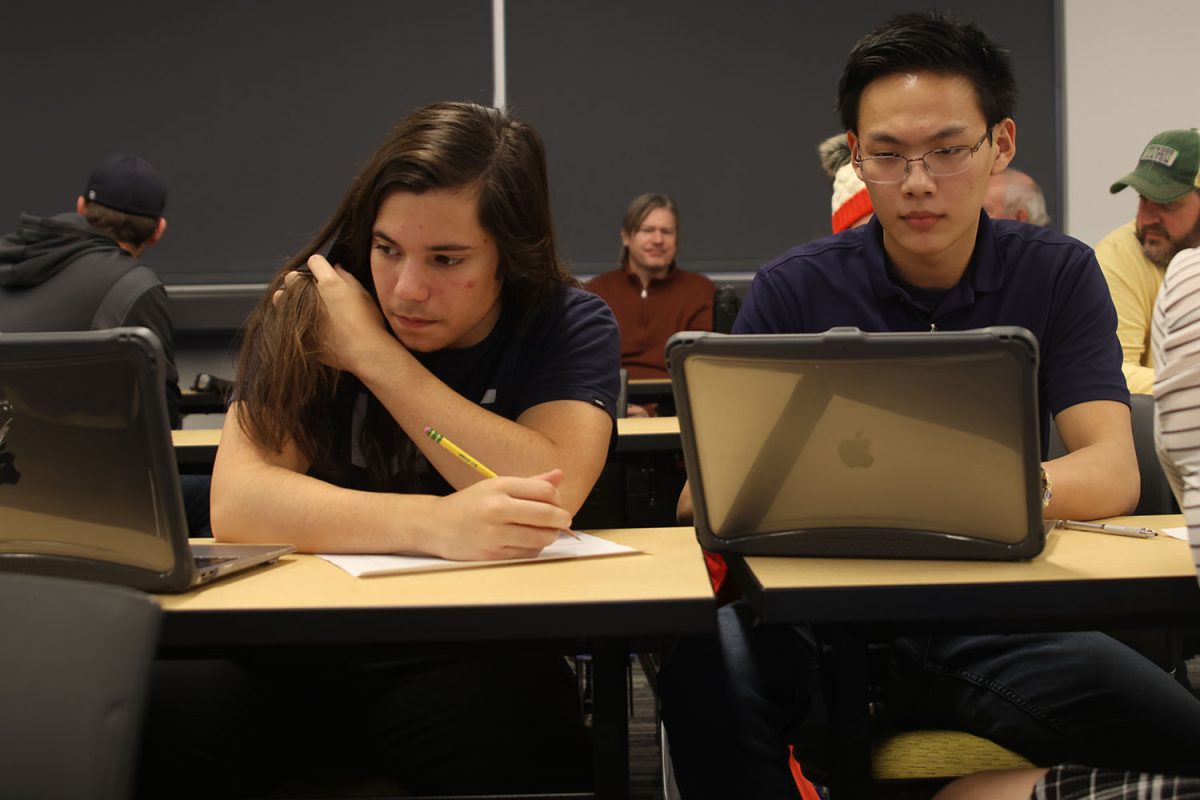 Side by side, juniors Fabian Hernandez and Zach Chang work to complete their rules worksheet on Thursday, Dec.12.