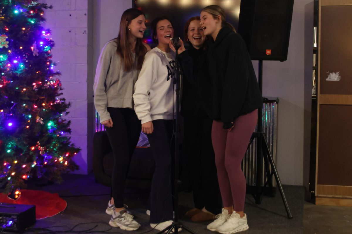 Singing "Grenade" by Bruno Mars seniors Emmie Chezem and Brynn Shideler gather around the micrphone next to sophmores Hadley Doyle and Kenna Long. 