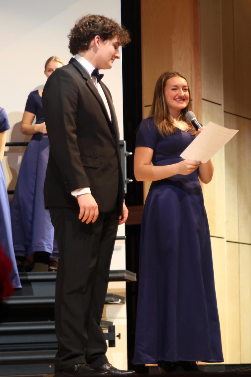 Seniors Allyson Makalous and Blake Gray introduce the themes of the winter choir concert.