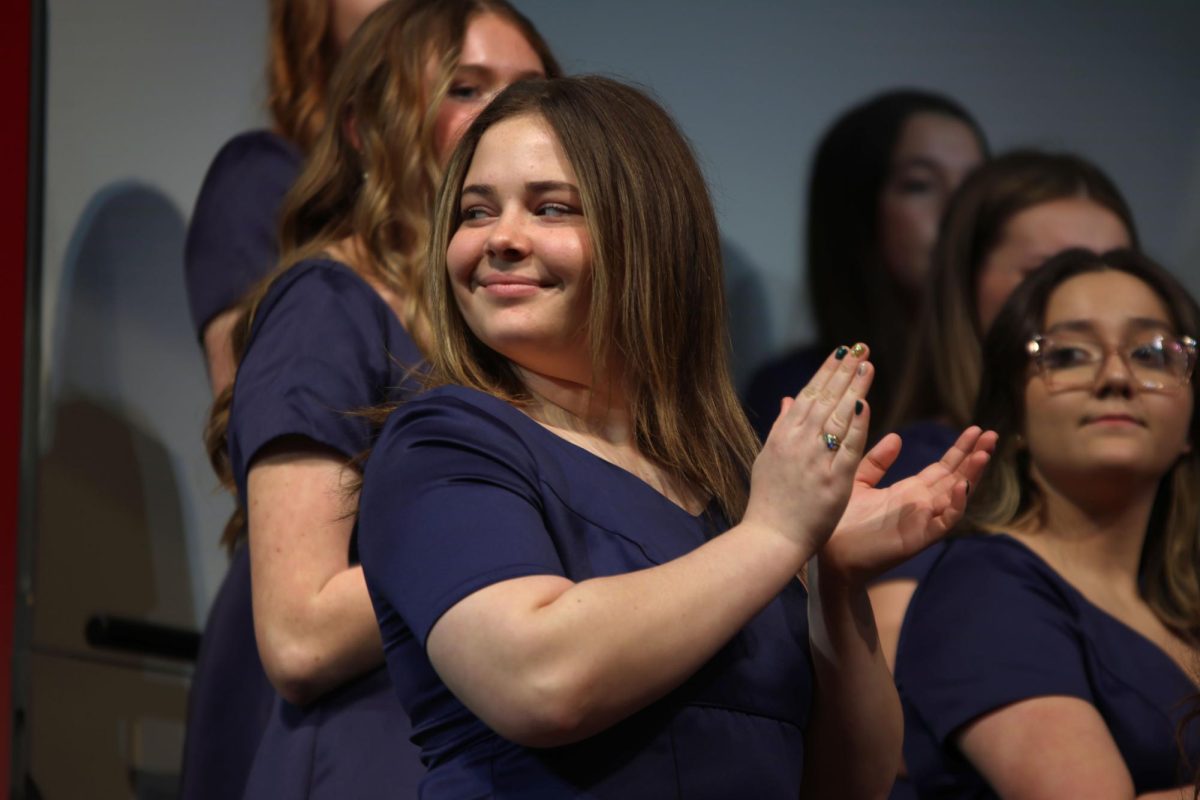 Clapping, senior Alaina Sweany applauds the musicians that performed with the choir.