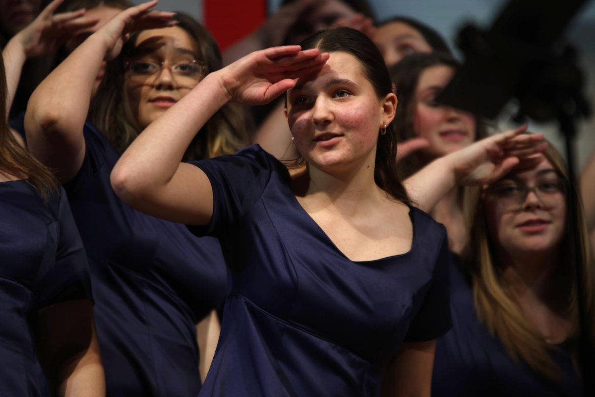 Looking, junior Ella Kaemmer dances while singing. 