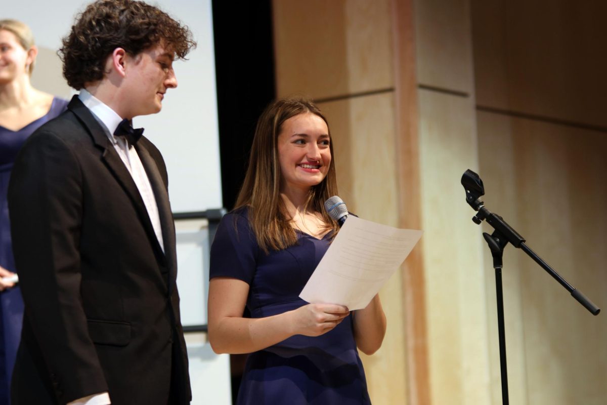 Smiling, choir president senior Allyson Makalous gives a speech before the performance. 