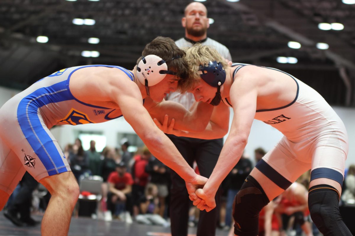 Heads together, senior Colton Bendure butts heads before his match.