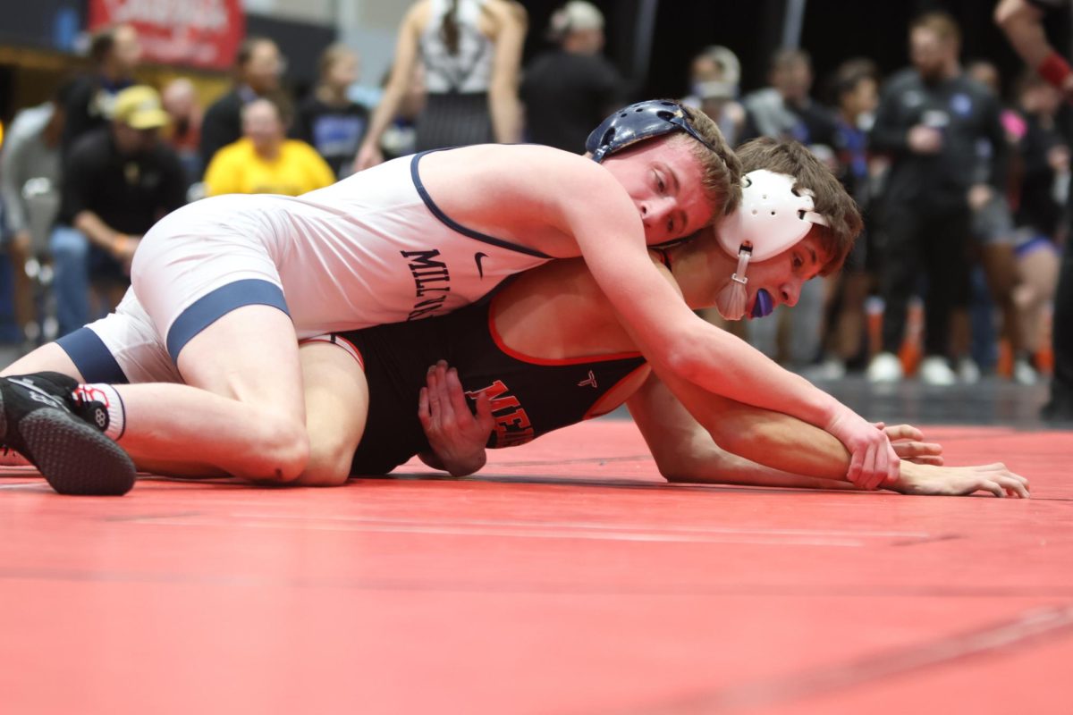 Pinning down his opponent, junior Jeredy Nilges holds his opponents arms.