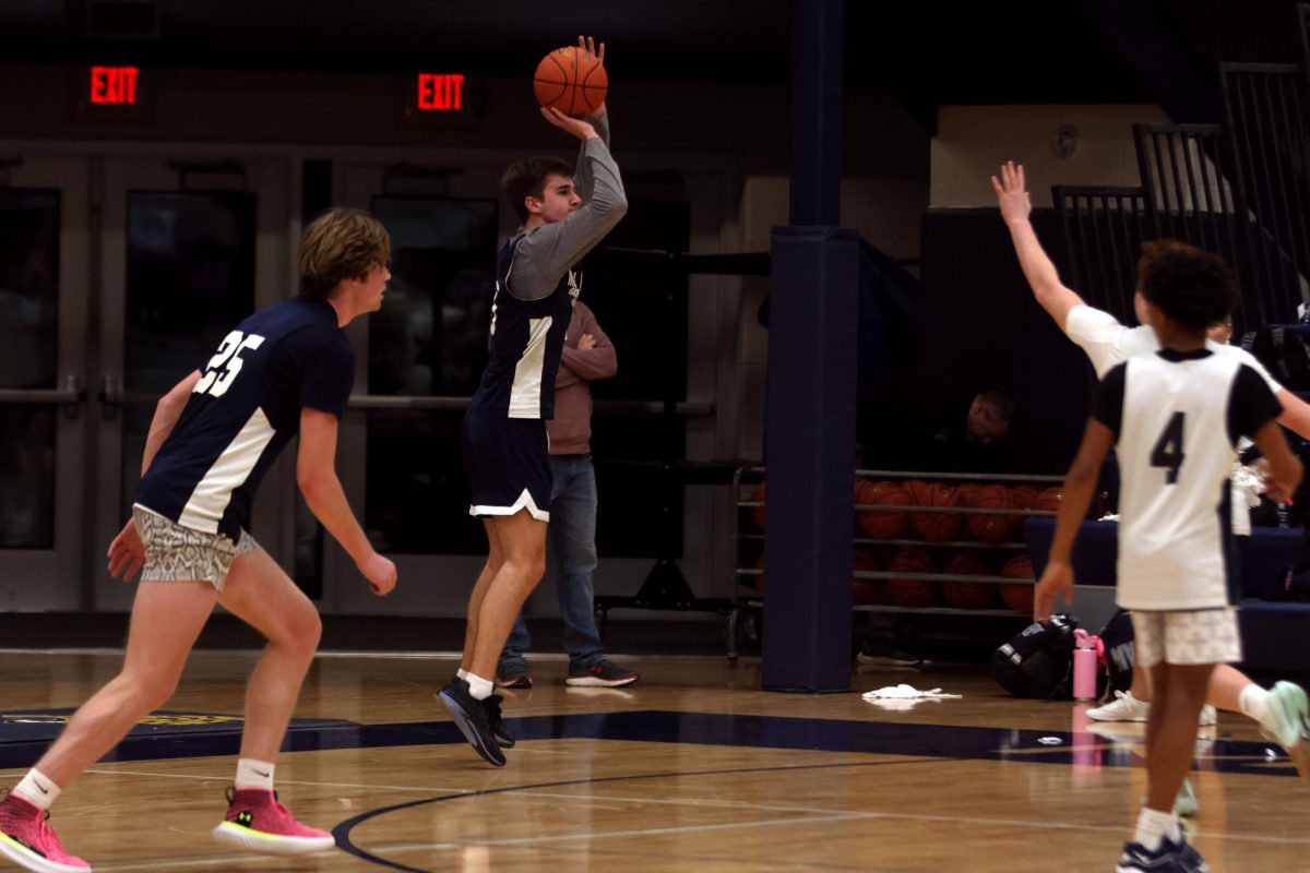 Thatcher Ivey attempts a threee point shot over defense in a scrimmage on Friday Decmber 6th