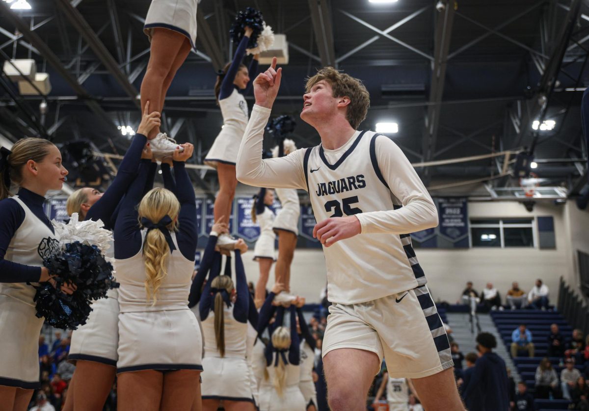 Pointing towards the sky, senior Carter Kaifes finishes his pregame handshake.