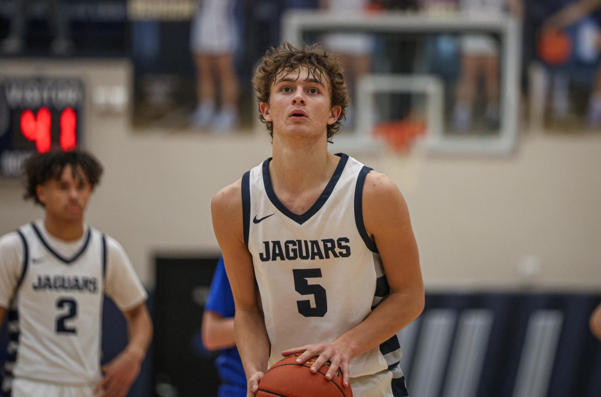 Looking towards the rim, junior Reece Riedel attempts a free throw.