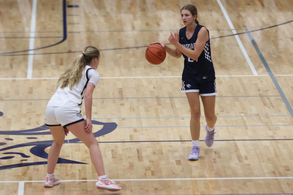 During the basketball scrimmage, senior Averie Landon dribbles the ball across the court as sophomore Riley Marshall plays defense on Friday, Dec. 6.