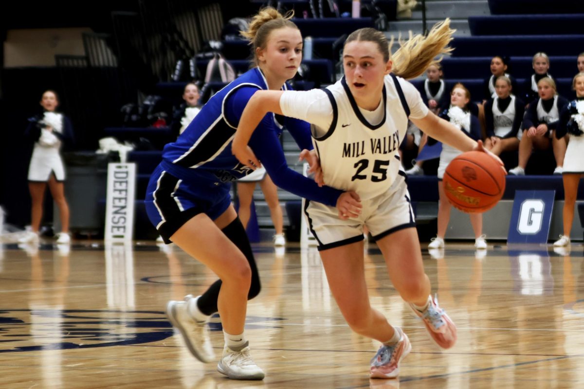 Sophomore Riley Marshall battles against the opposing team to carry the ball down the court. 