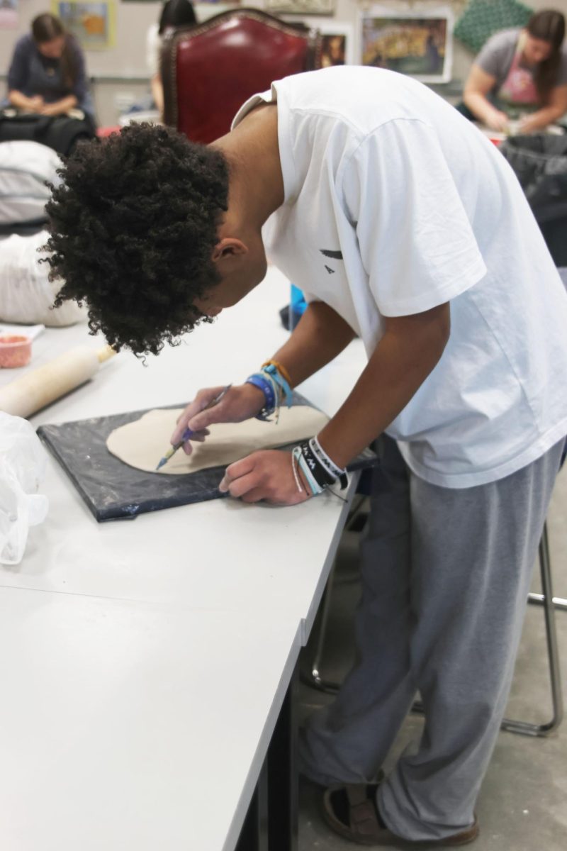 Starting his project, sophomore Sean Williams cuts out a shape in his clay. 