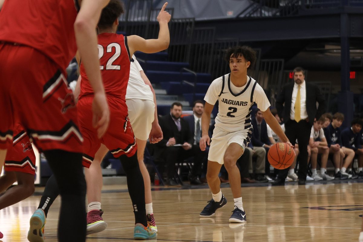 Looking for a way pass the defenders, junior JaKhai Carter dribbles the ball through his legs. 