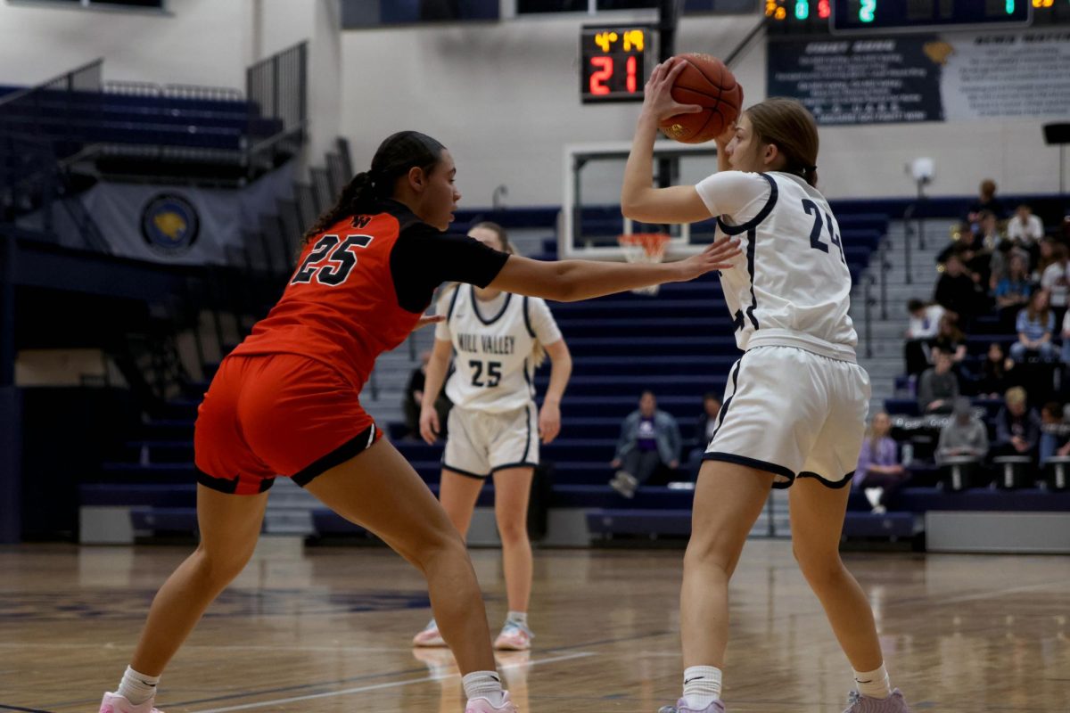 Holding the ball away from the opponent, senior Averie Landon looks for an open teammate. 