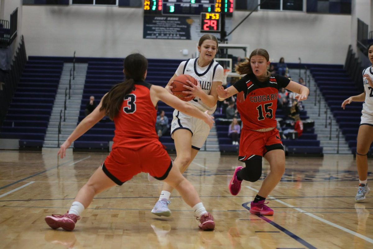 With defenders by her side, senior Averie Landon drives hard to the basket.