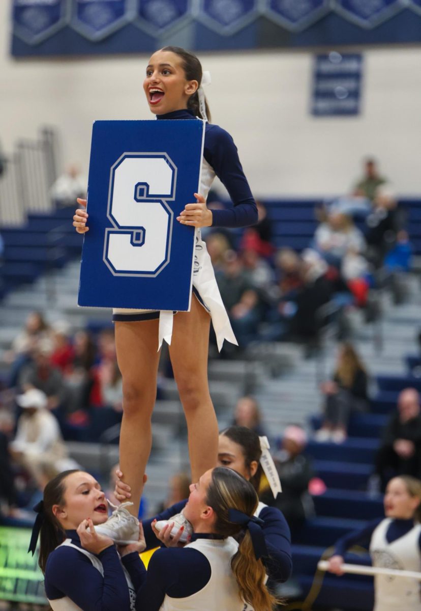 Senior Jada Winfrey yells to the crowd while cheering in a stunt.
