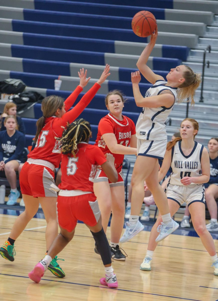 Shooting the ball, senior Josie Benson jumps up to avoid Shawnee Mission North’s defense. 
