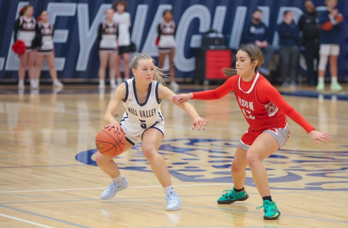 Dribbling, senior Josie Benson dodges an opponent in an attempt to steal the ball.
