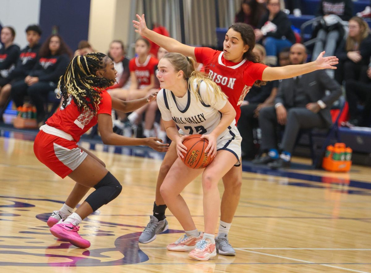 Holding tightly, sophomore Riley Marshall guards the ball while trying to pass it.
