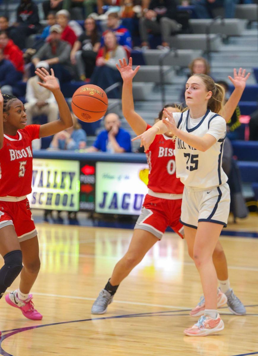 Tossing the ball to a teammate, sophomore Riley Marshall moves the ball across the court.
