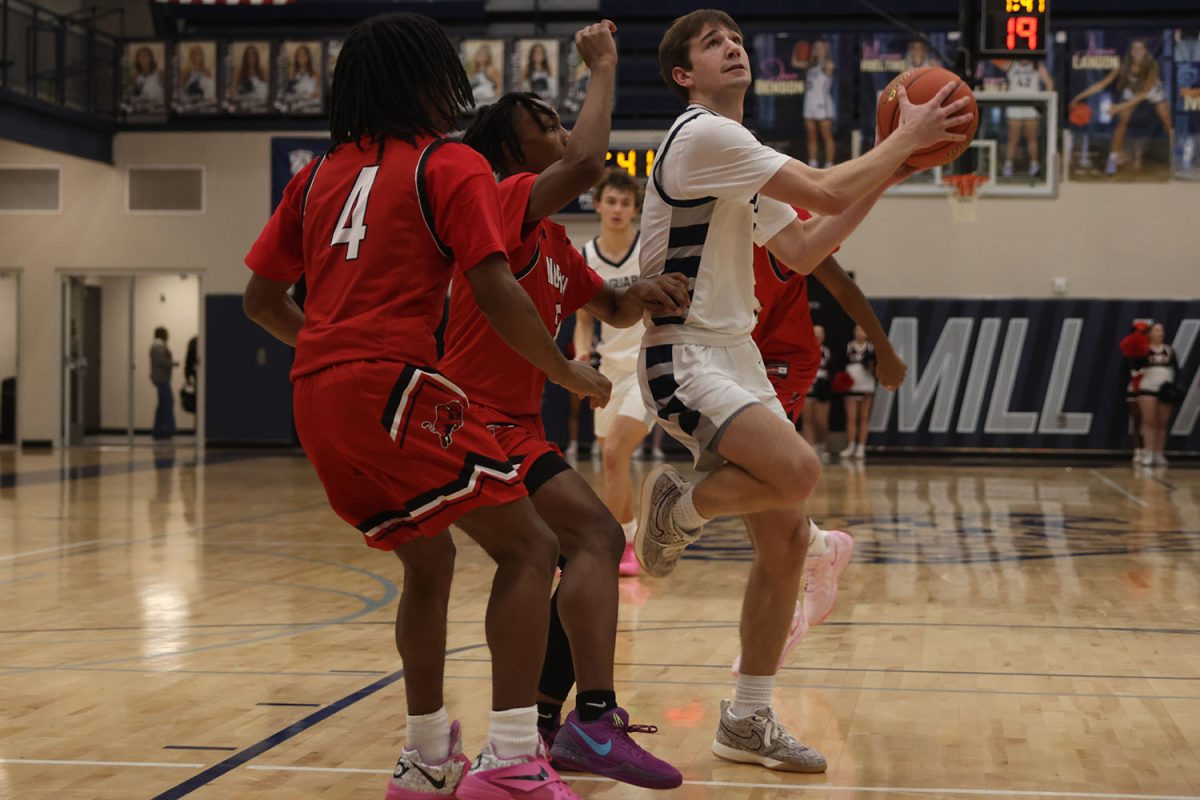 Jumping for the shot, senior Thatcher Ivey gets past his defenders. 