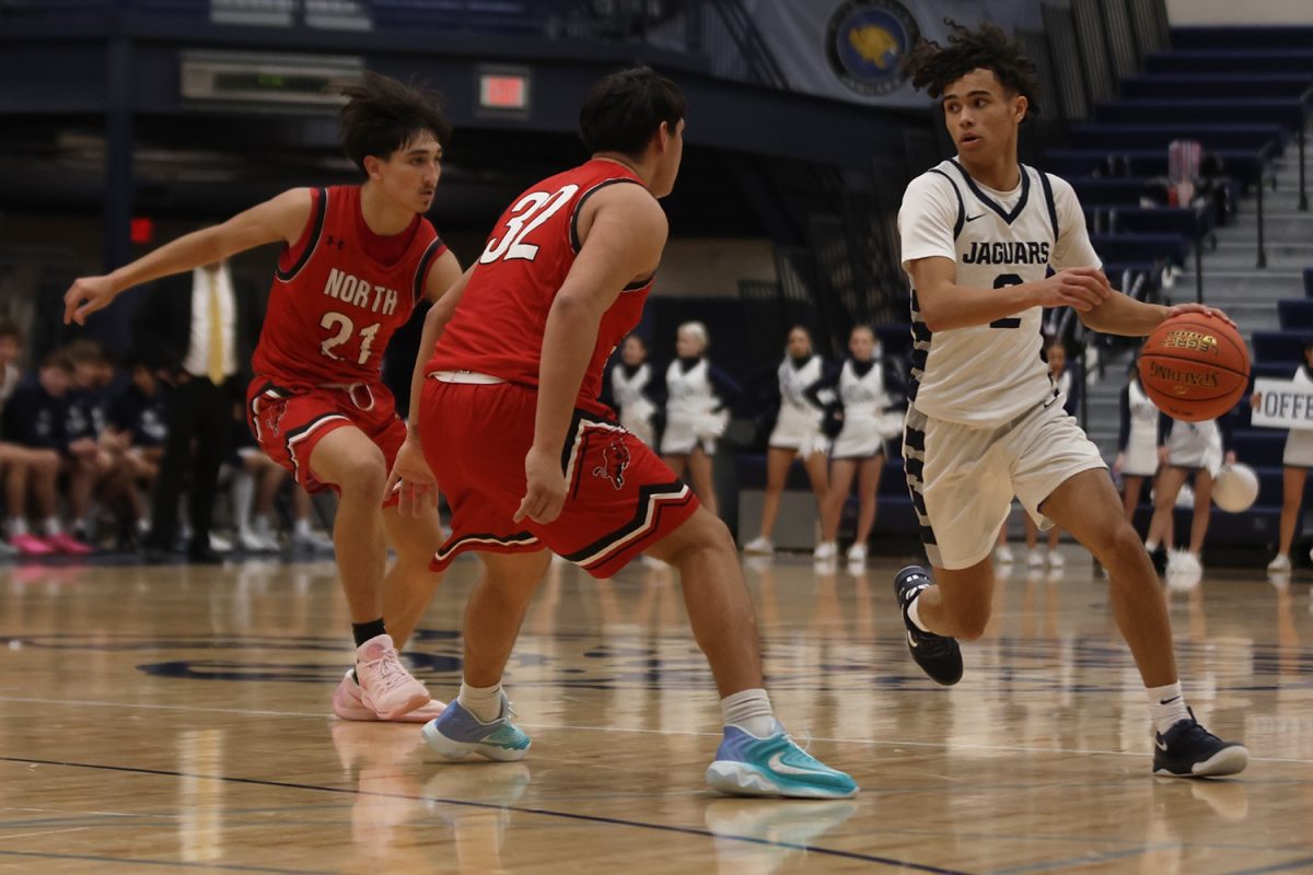 Looking for help from his teammates, junior JaKhai Carter tries to pass the ball. 