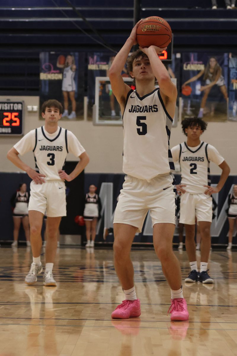 Focusing on the basket, junior Reece Riedel shoots for a point. 