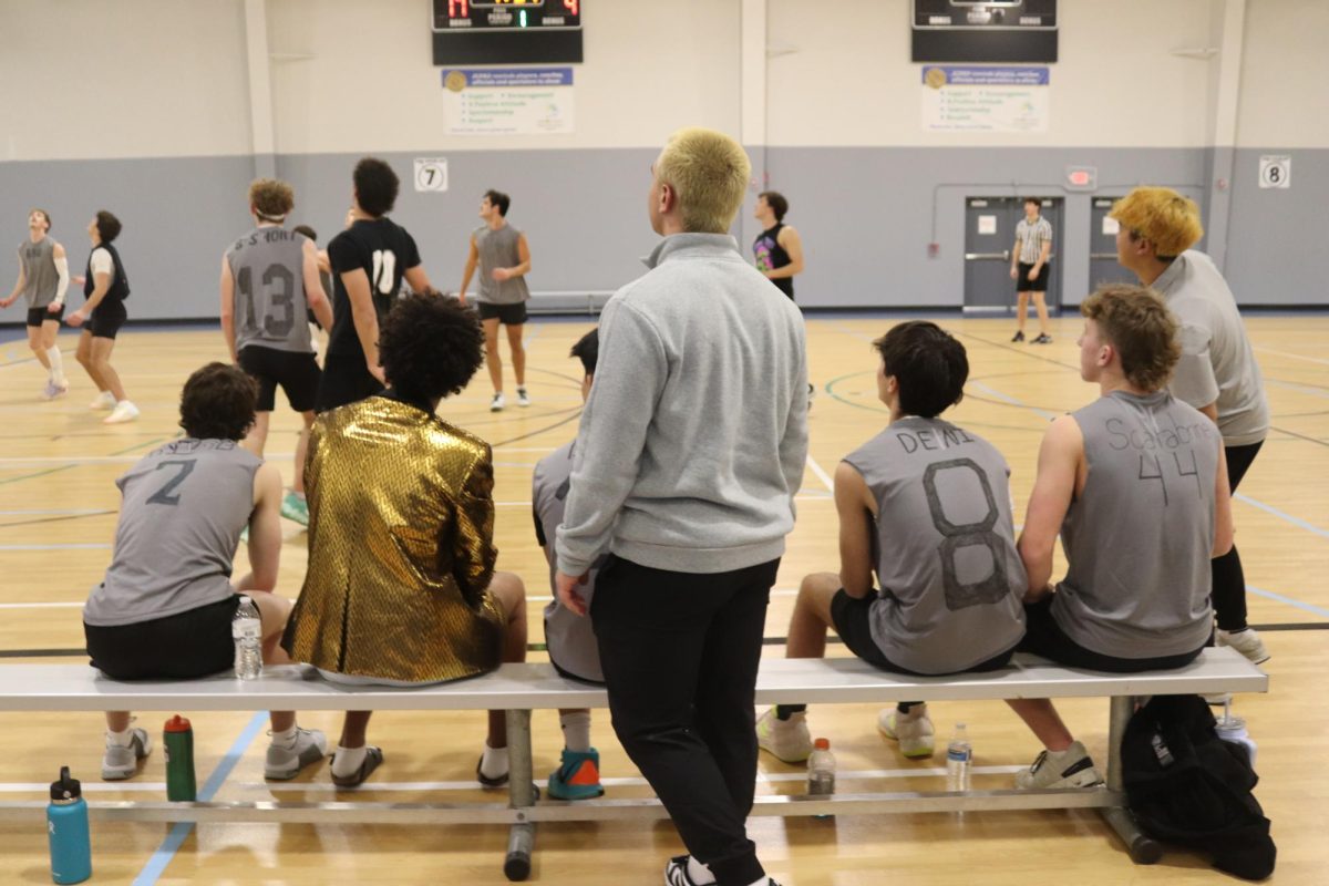 Senior Zach Zaldivar watching the game with his players on the bench. 
