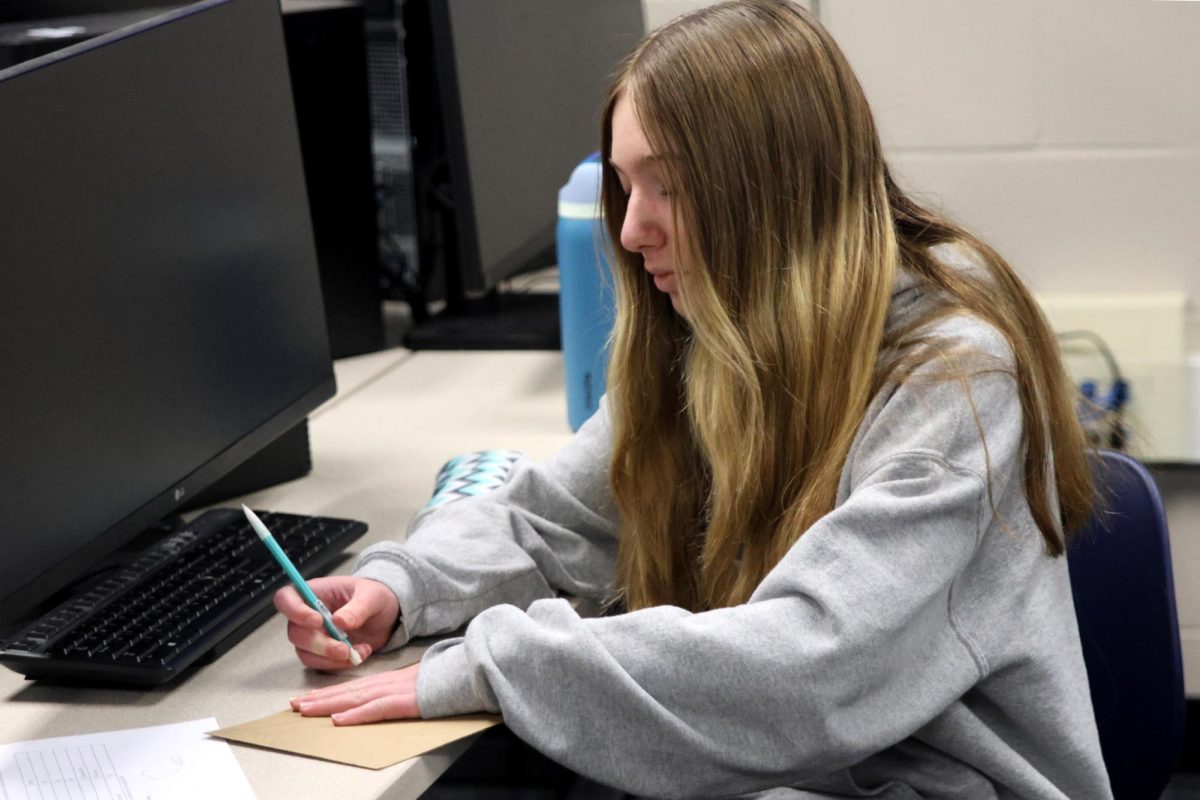 Thoughtfully drawing out her design, freshman Delaney Konen helps to create the main body of her team’s airplane. 