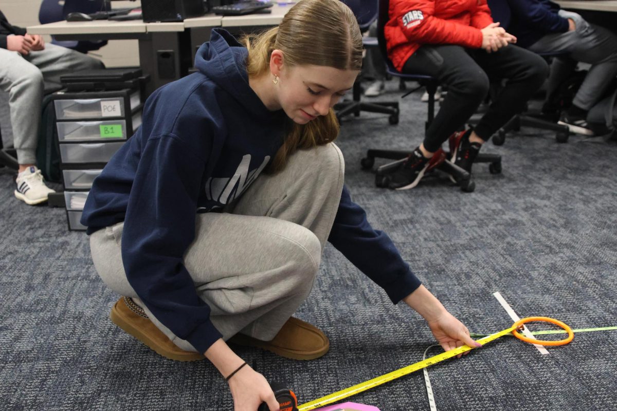 Measuring carefully, freshman and SWENext secretary Mia Kenkel ensures she is being as detailed as possible to determine the winners.