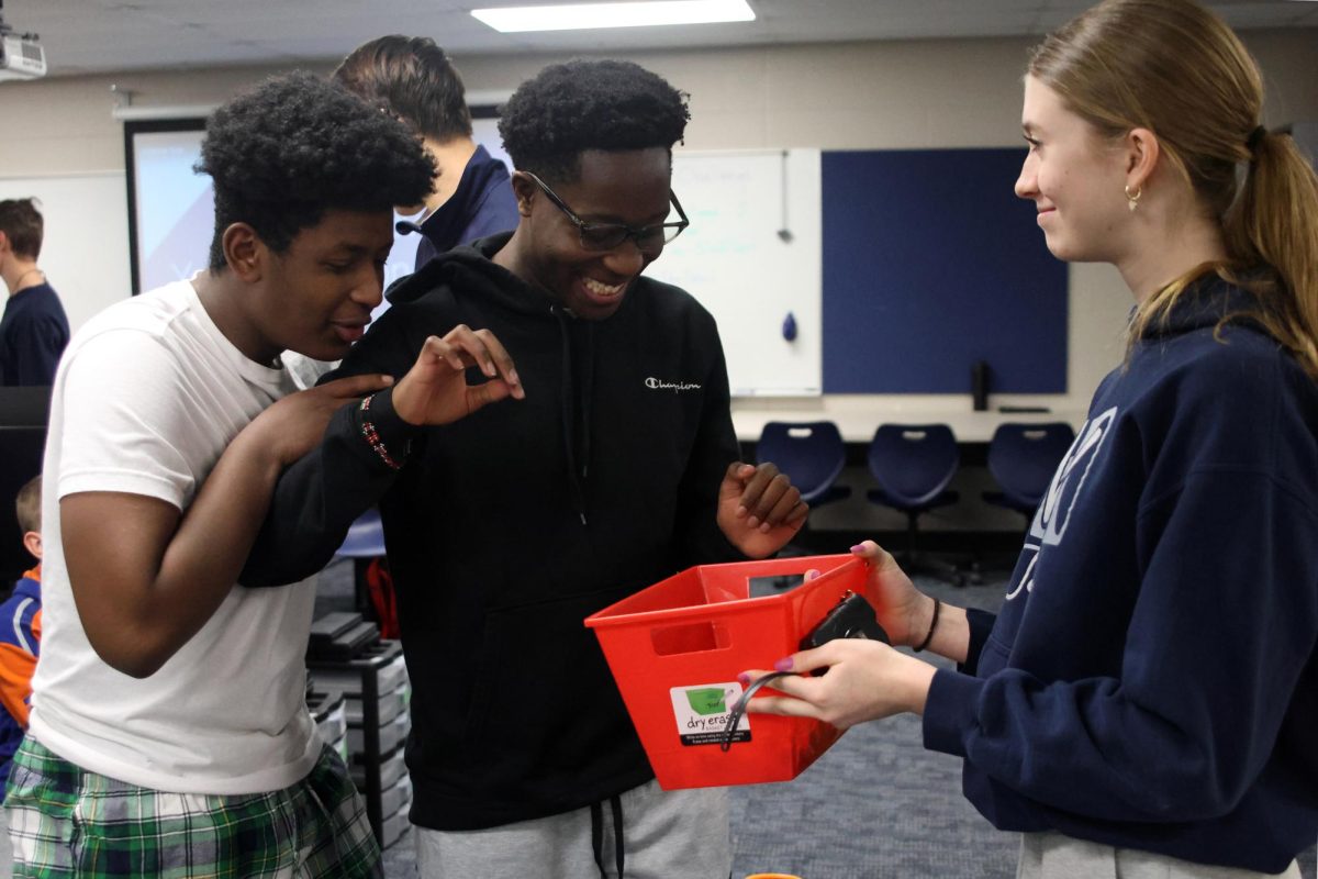 SWENext secretary and freshman Mia Kenkel hands candy out to the winners of the ‘Wings of Tomorrow’ challenge’, freshmen Natnael Vega and Bryan Mboya.
