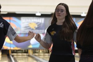 Fist bumping another teammate, sophomore Ella Diehl celebrates after getting a strike.