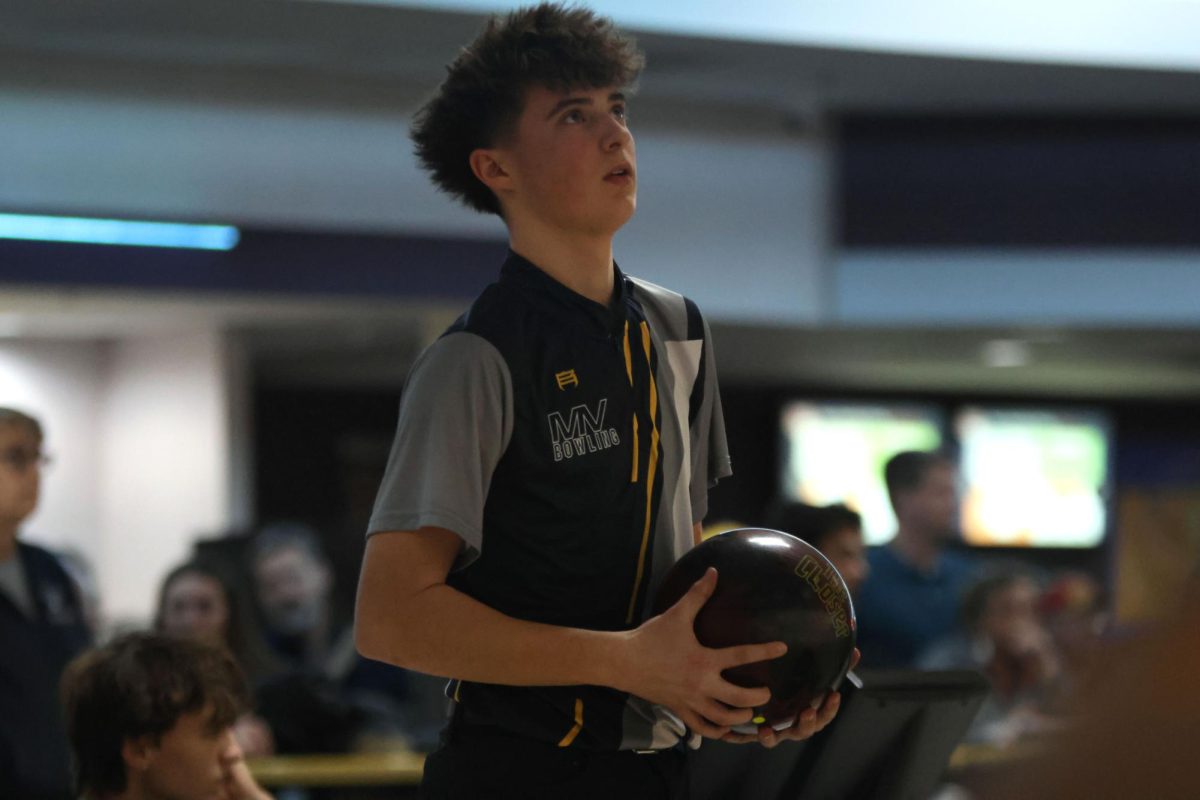 Looking up at the scores, sophomore Lincoln Goertz prepares for his next turn. 