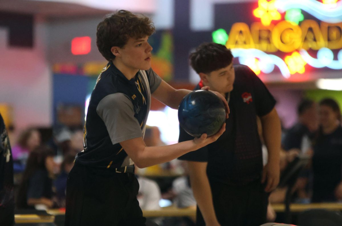 Holding the ball, sophomore Devin Leiker looks down the lane.