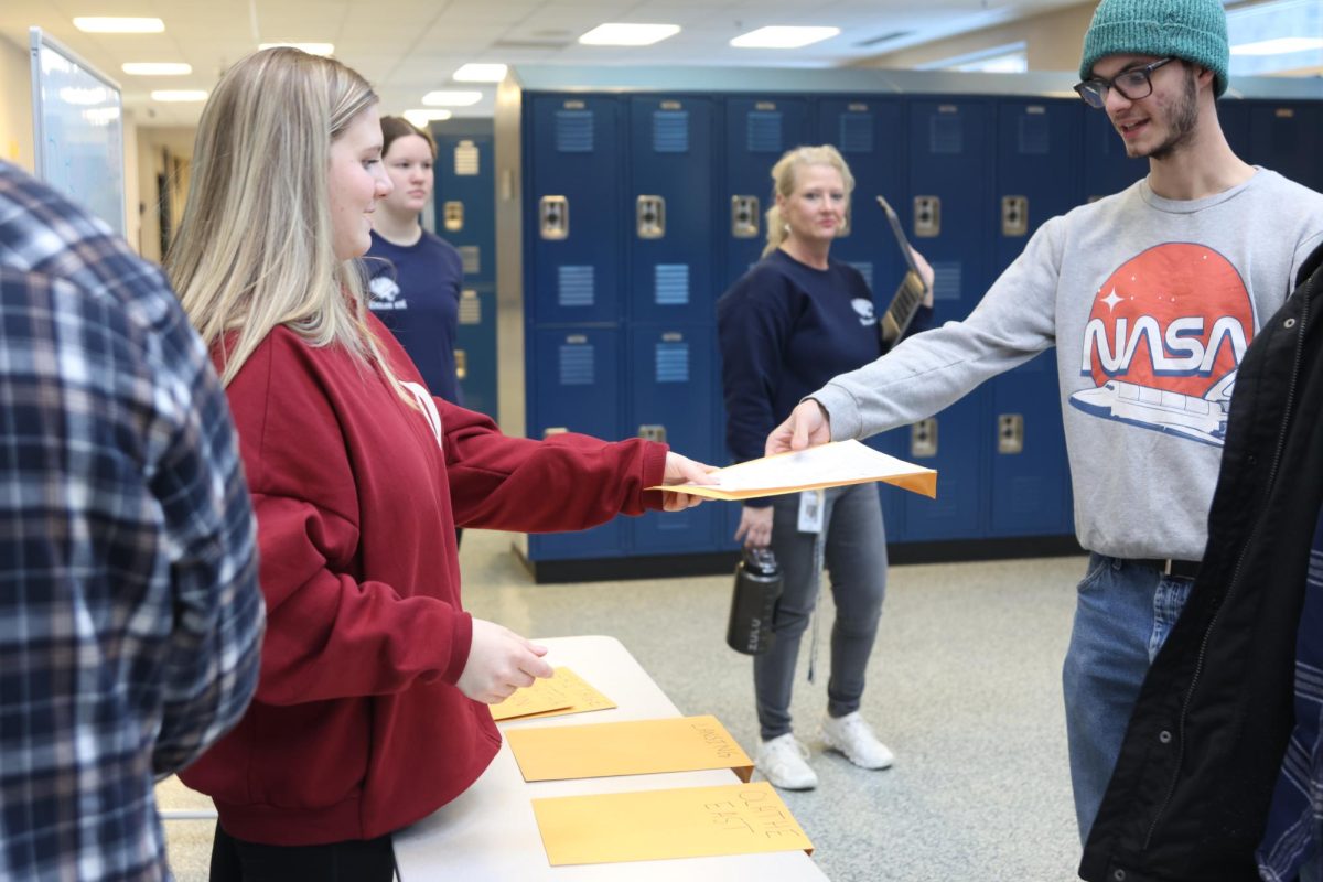 Junior Elaina Weese greets arriving teams at the main entrance.