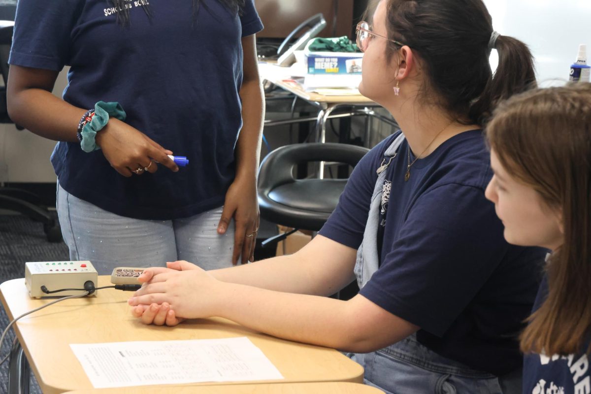 Juniors Quinlyn Peters, Doreen Mahugu, and Ana Rios prepare their room before teams arrive.