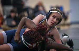 Holding down her opponent, sophomore Autumn Anderson looks towards the scoreboard.